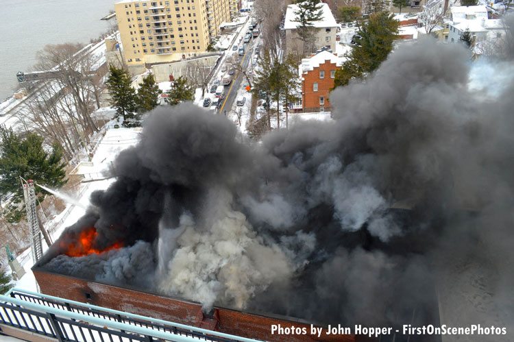 Flames and smoke pour forth from the roof of an apartment in Yonkers, New York.