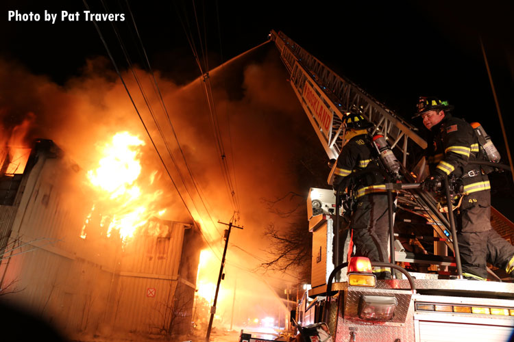 Firefighters on an aerial apparatus at a warehouse fire in Rockland, Massachusetts.