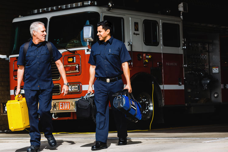 Firefighters with a fire truck inside a station bay