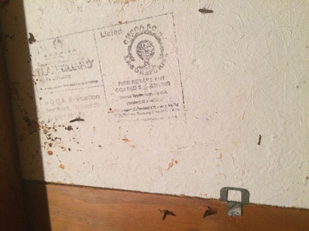 (4) This 1980s-era white sheet of plywood is fire retardant treated and placed next to a fire wall in the roof deck. Note the testing lab certification printed on the surface. <i>(Photo courtesy of David Barthold.)</i>