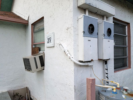 (2) This window air-conditioner was running even though the electric service wires had been cut and there were no electric meters. Firefighters suspected theft of electricity. <i>(Photos 2-7 by James Dupre.)</i><b>“></td>
</tr>
<tr>
<td align=