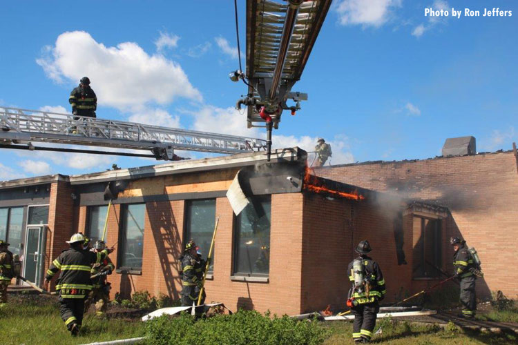 Firefighters work to contain a fire in a building that was sparked by a plane crash in Carlstadt, New Jersey.