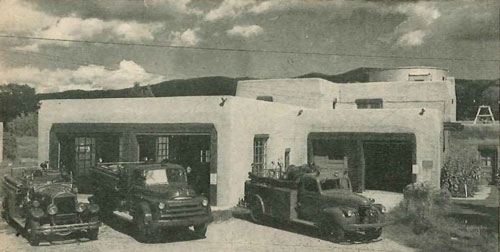 (3) Volunteers build many a fine fire station. Witness this home of the Taos, N. M., Fire Department, down in the adobe country. Most of the money and labor - for this headquarters - built a section at a time - came from local folks. Total inventory, apparatus and equipment worth over $100,000. Permanent fireman and wife have apartment upstairs. This photograph shows station and apparatus. Note type of architecture which blends with local construction. 