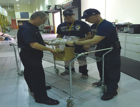 (2) Assistant Chief Todd Leduc and BCSDFR firefighters overpacking soiled hoods for advanced testing.