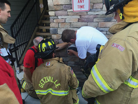 (1) Before leaving the scene of a routine fire alarm activation at a commercial building, these firefighters familiarized themselves with the fire department connection. In addition to reviewing how to properly hook up the feeder hose, the officer also reviewed the department’s SOPs for standpipe-equipped buildings. <i>(Photos by author.) </i>.