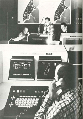 (1) Dispatchers work at computer terminals with maps of Manhattan fire units in background.