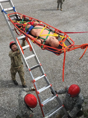 (14) A rescuer walks the basket to the ground as the rope lowers it. 