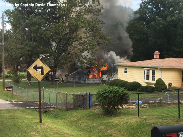 Chattanooga firefighters train a hoseline on a house fire