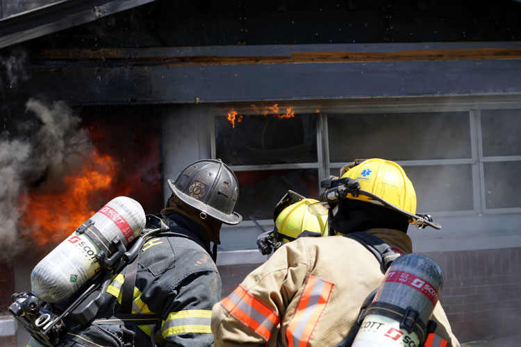 Firefighters confront flames at a burning home