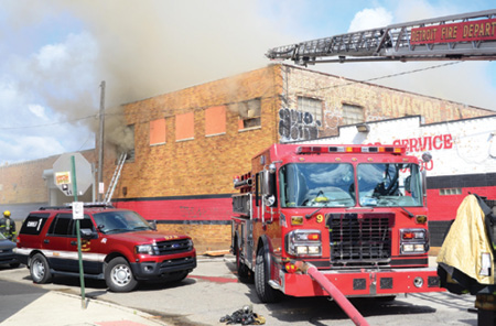 (1) Conditions were changing shortly after arrival as crews stretched and started to operate on the interior of the fire building. Note the aerial ladder positioned at the corner, allowing access to the A and D sides of the fire. (Photos by Dennis Walus.) 