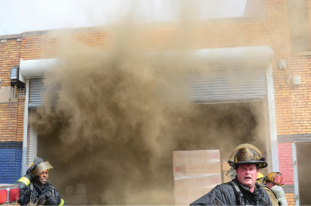 (4) Interior firefighters exit the building after the IC issues the evacuation order and the operation transitions to defensive. (5) After the transition to defensive operations, firefighters on an exposure building roof prepare to operate from a point of advantage.