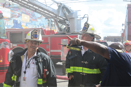 (7) The IC in a face-to-face discusses the firefight’s progress. He is also in constant communication with interior company officers and managing the incident and the safety of all on-scene members. Constant communication is essential throughout any size incident.