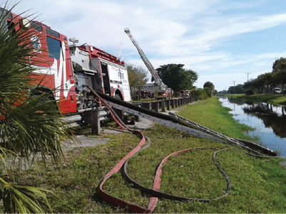 (2) Engine 35 works to obtain a draft through 30 feet of hard suction hose and three ground ladders to achieve the desired lift. 