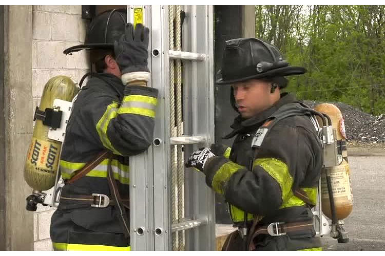 Firefighters raising a ladder