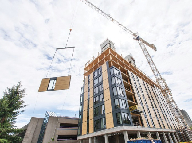 (3) A cross-laminated timber panel is lifted into place. 