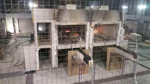 (5) During large-scale fire testing of mass timber, little fire remains within a two-story CLT structure that withstood a nearly 20-MW peak fire exposure for four hours. For the test, contents were placed and ignited only in the second-floor, one-bedroom apartment. In each room, an 8- × 10-foot portion of the CLT ceiling was left exposed. The remainder of the mass timber surfaces were protected by two layers of 5⁄8-inch Type X gypsum wall board. 