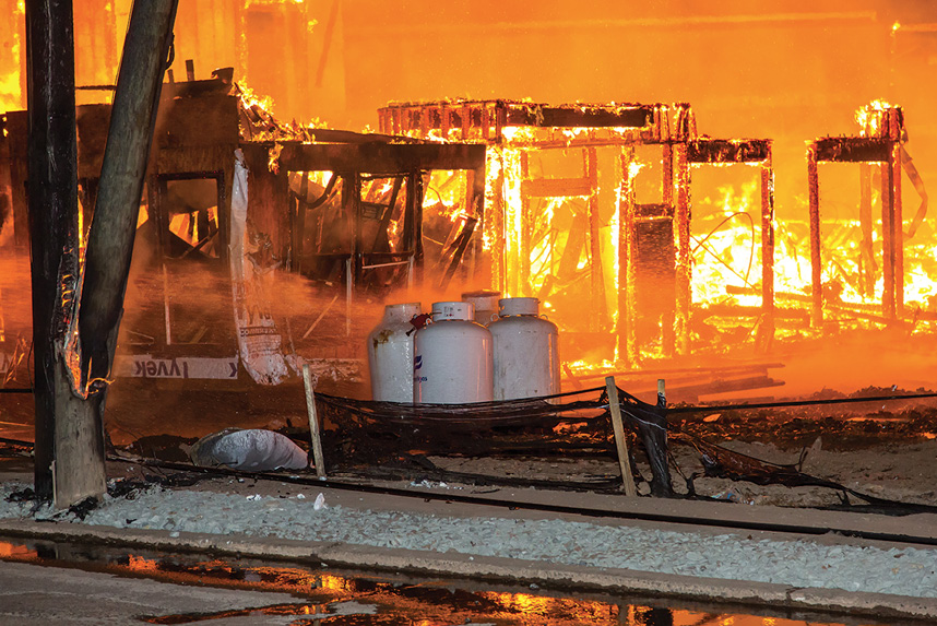 (2) A firefighter cools four of the 12 LPG tanks in proximity to the fire. (Photos by Peter Danzo, PAD Photography, unless otherwise noted.)