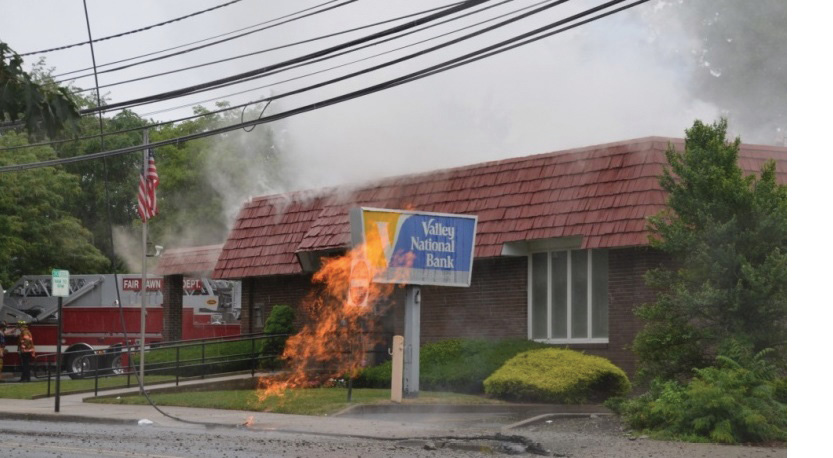 (2) Smoke is showing from the roof of the building, indicating a fire within the building.