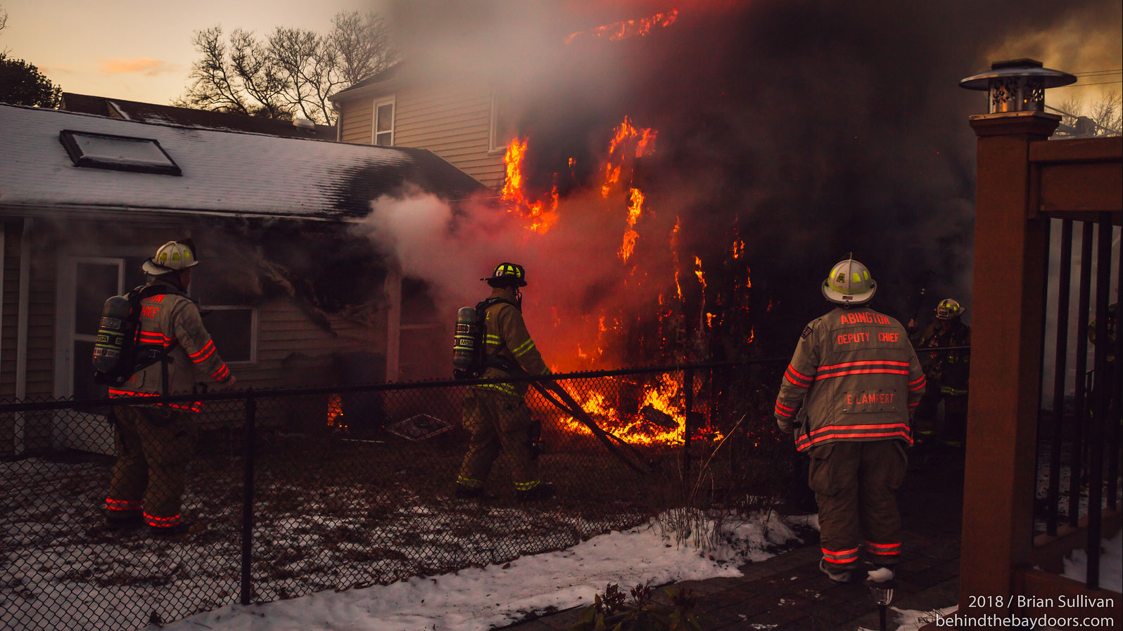 Firefighters pull a line to fight a house fire in Pennsylvania