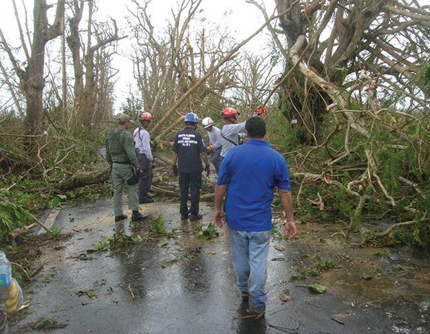 (1) TF members help locals to clear a road. (Photos courtesy of Virginia Task Force 2.)