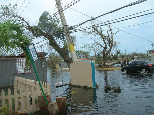 (2) Loiza, showing minor flooding on the main road, a broken utility pole, and down power lines.