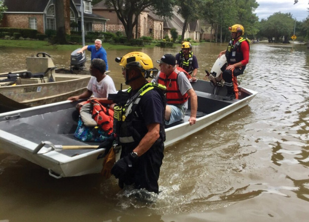 (5) L.A. County firefighters assigned California US&R Task Force 2 conducting waterborne search & rescue operations in Houston. (Photo courtesy of the L.A. County Fire Department.)