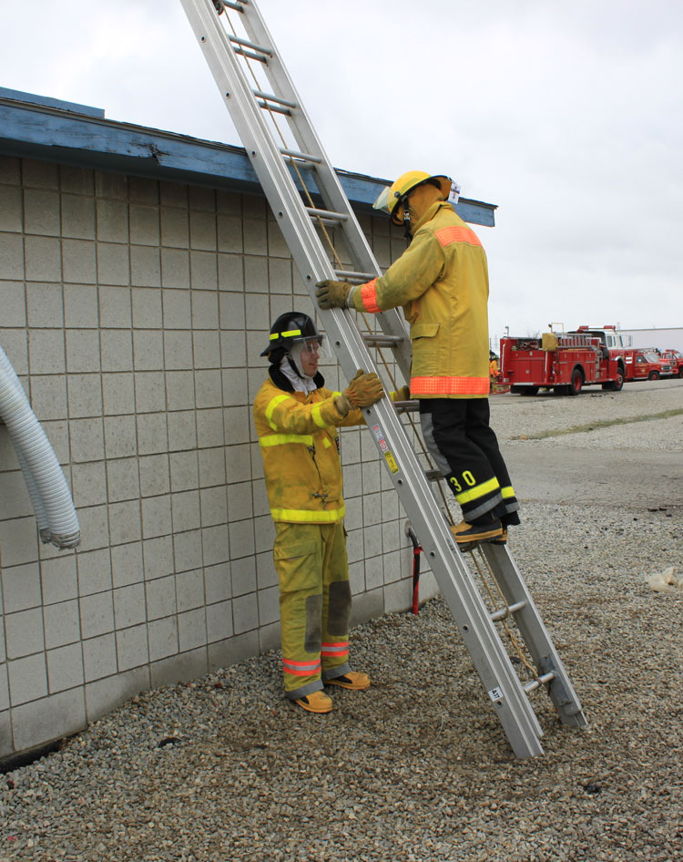 Firefighter footing a ladder