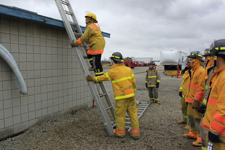 Firefighter footing the ladder from behind