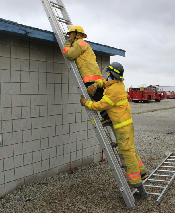 Firefighter pins a falling member on the ladder