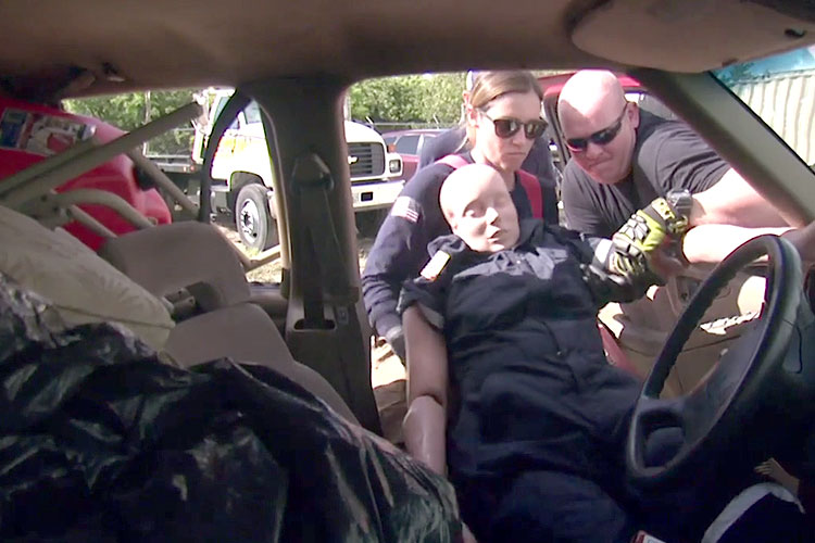 Rescuers remove a dummy patient from a hoarder vehicle during training