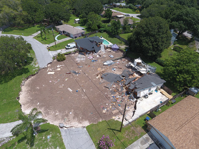 (3) The sinkhole as seen from 100 feet above the ground at its largest extent, showing the destruction of two homes.