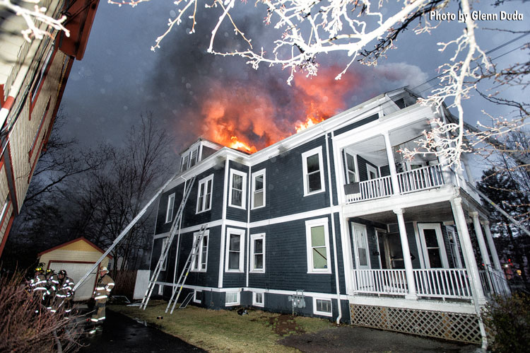 Firefighters put water on house fire as flames burn through roof