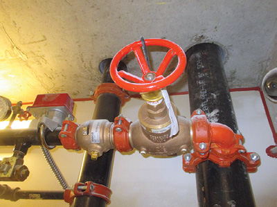 (4) A check valve, between the sprinkler floor isolation valve and the water flow alarm switch, prevents water from draining back into the riser.