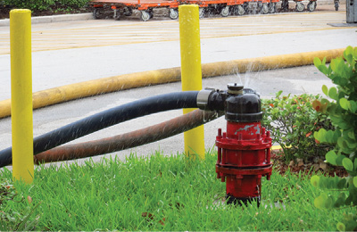 (8) Two three-inch hoselines supply a sprinkler system’s FDC. One of the first actions firefighters should take is to pressurize the FDC. This will give the sprinklers their best shot at controlling the fire before firefighters gain entry and control the fire with hoselines. [Photo courtesy of the Miami-Dade (FL) Fire/Rescue Department.]