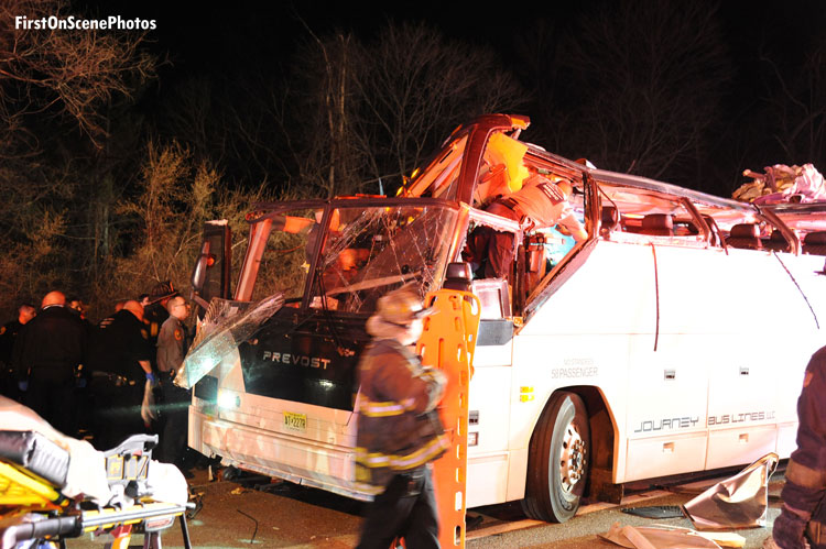 Firefighters work at the scene of a Long Island bus crash