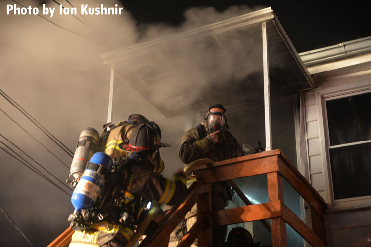 A firefighter masks up before entering a structure fire