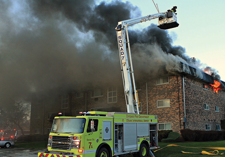 (3) Members of Squad 7 are awaiting water. We can see from the smoke that the fire now is spreading throughout the cockloft space. 