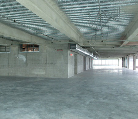 (12) A floor of a commercial high-rise building before it is occupied by offices. The supply heating, ventilation, and air-conditioning duct extends from an air handler in the core; there is no return air ductwork. When the ceiling is installed, air will return in the plenum space between the ceiling and the floor above to the air handler. (Photo by Blas Bravo.) 