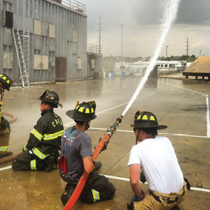 (1) The positioning of the firefighter’s rear hand allows for the hoseline to be “pinned” up against the firefighter’s hip to assist in resisting the nozzle reaction forces. (Photos courtesy of Brian Brush.) 