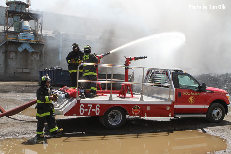 Chicago firefighters operate a deck gun at a scrap yard fire