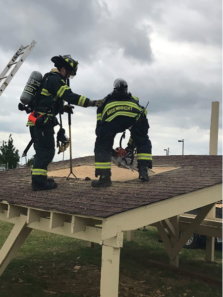 (3) Senior members should be the most experienced technique coaches. Truck company members are reviewing saw techniques while performing a ventilation task.