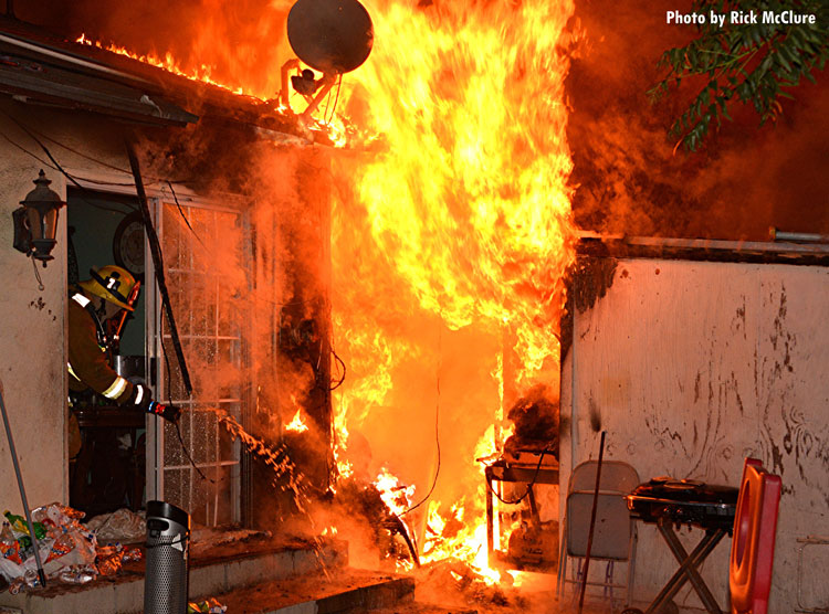 Firefighter applies water to house fire in Los Angeles