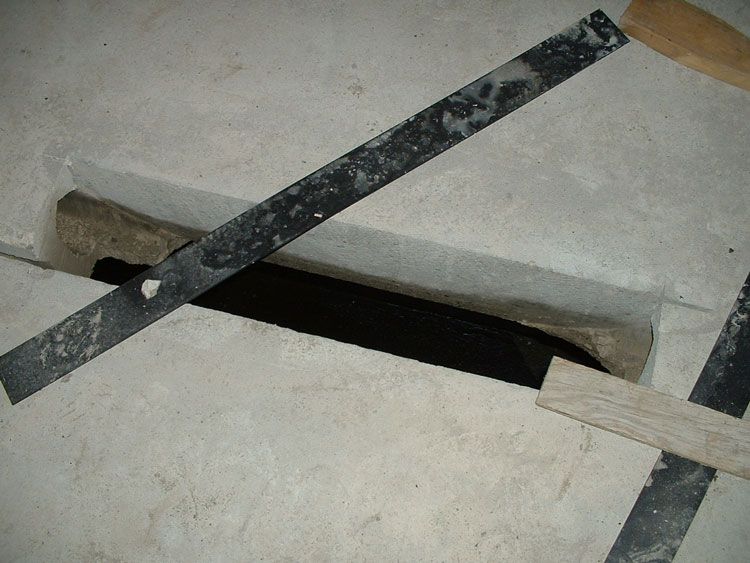 An opening in a precast concrete plank subfloor