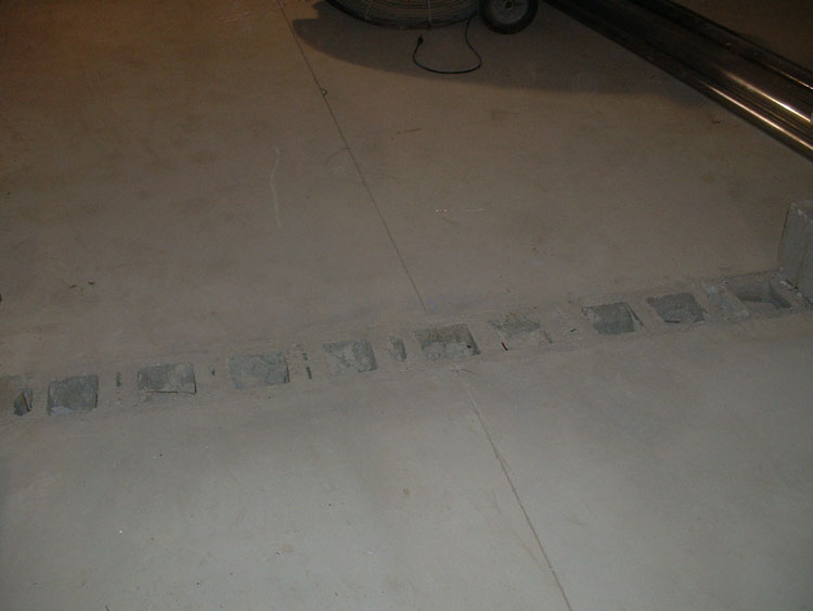 Concrete floors that have been poured flush with the top of a wall of concrete masonry units