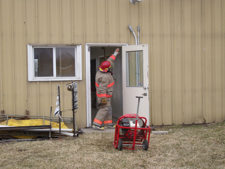 Firefighter checks for air cone on PPV fan