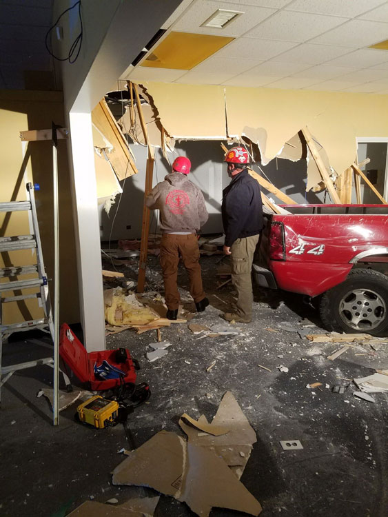 Technical rescue team firefighters clear a path through the structure