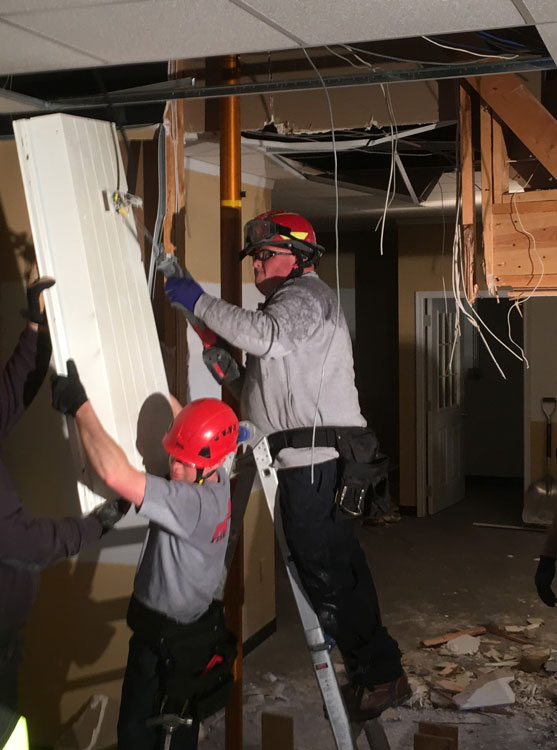 Firefighters remove suspended lighting