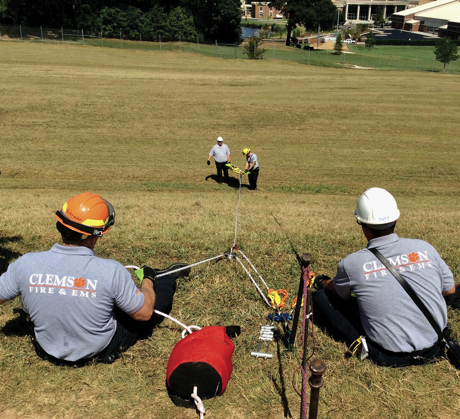 These Clemson University (SC) firefighters are training on a low-angle scenario. They are using an eight plate to control the descent of the rescuers on the basket. When rescuers reach the victim at a distance beyond the length of a simple 3:1 MA, they will construct a 3:1 MA Z-rig to help bring the team to the top of the slope.