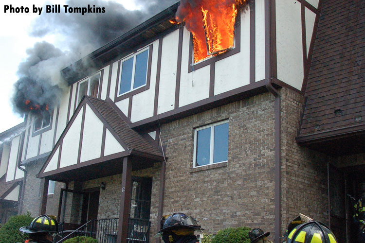 Fire vents through the roof of a town house