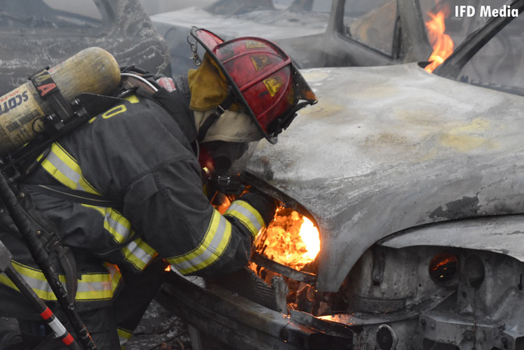 Firefighter examines fire in a vehicle